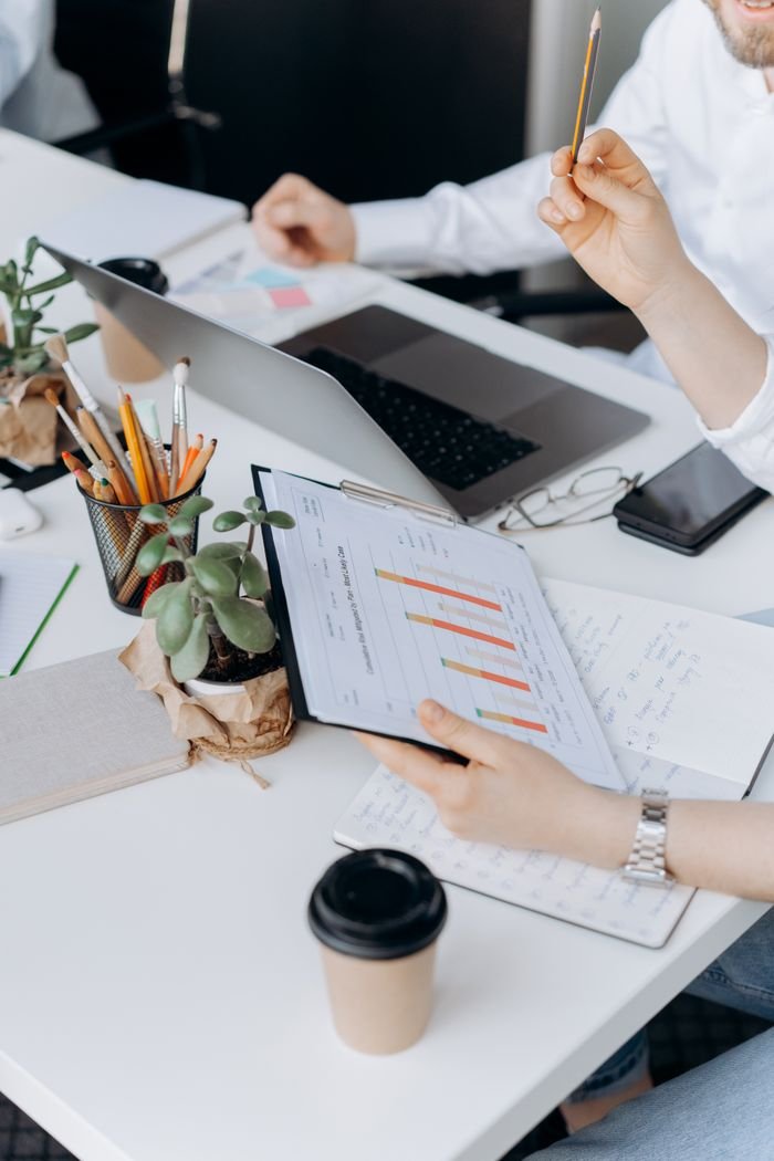 Mastering the First Impression: Your intriguing post title goes here Adults working on business analytics at office table with laptops and documents.