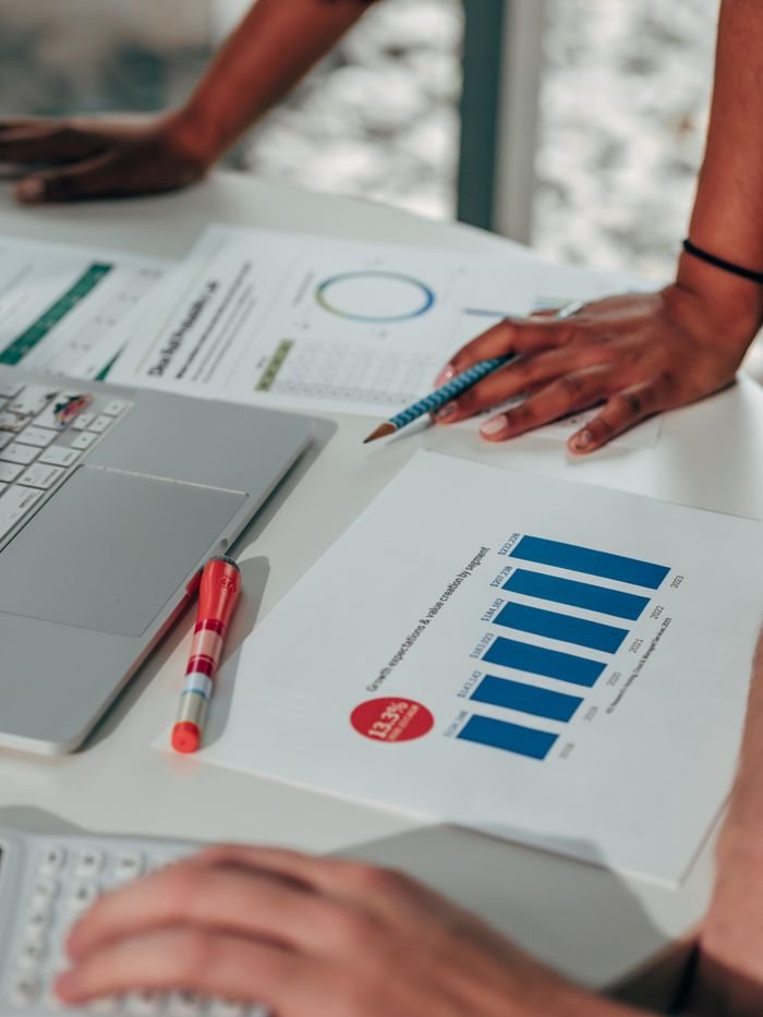 Crafting Captivating Headlines: Your awesome post title goes here Team engaged in analyzing business data with graphs and digital devices in an office setting.