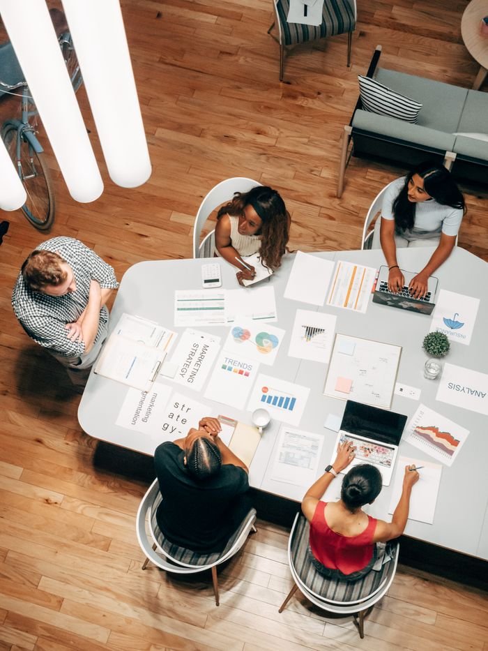About High-angle view of diverse team collaborating on a business project in a modern office.